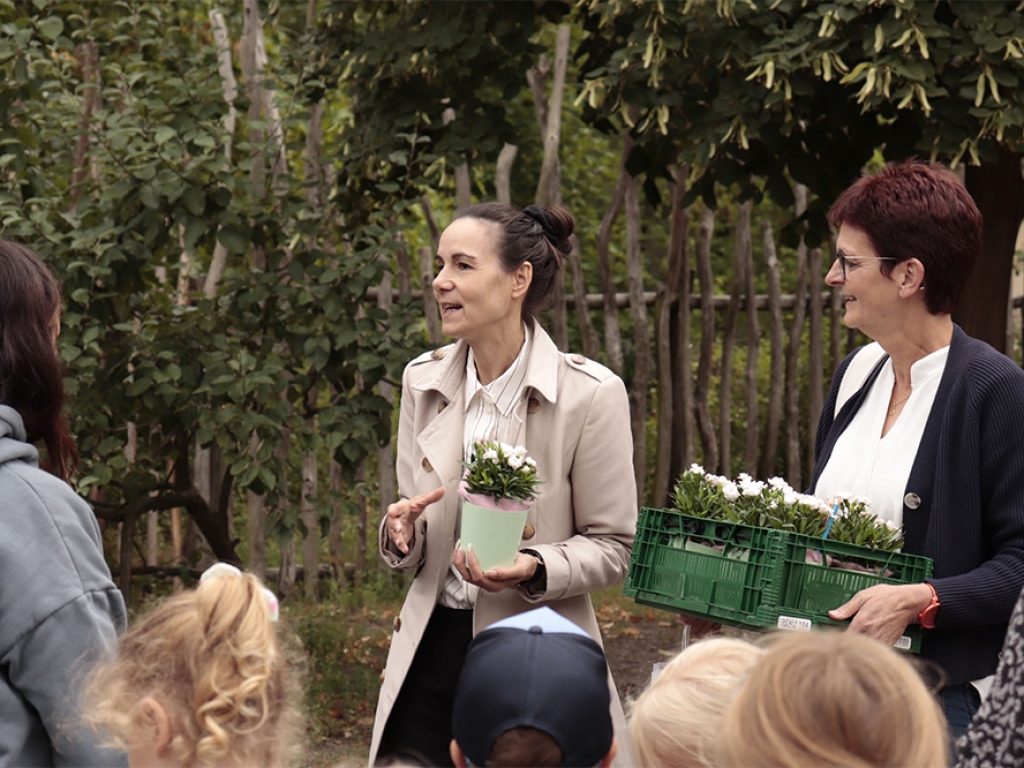 (v.l.) Bürgermeisterin Karolin Langner und Fachgruppenleiterin Steffi Domscheit bei der Übergabe der Blumenpräsente in der Grundschule der bundtStift_Schulen